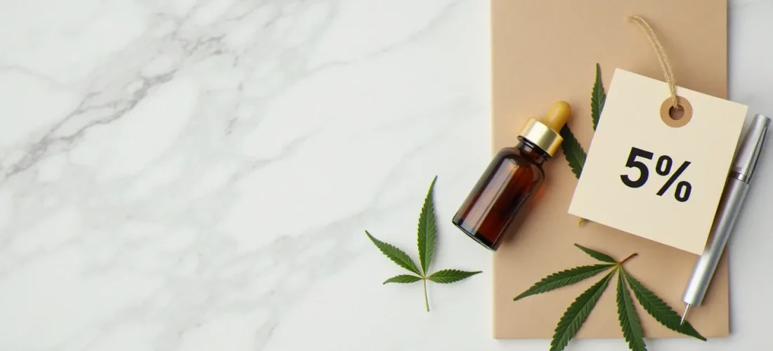 Flacon d'huile CBD avec un coupon de réduction 5% posé sur du marbre blanc, illustrant les économies possibles avec un 5 CBD coupon